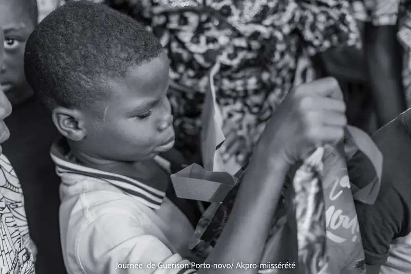 Un enfant découvre son kit scolaire offert lors de la Journée de Guérison et de Solidarité