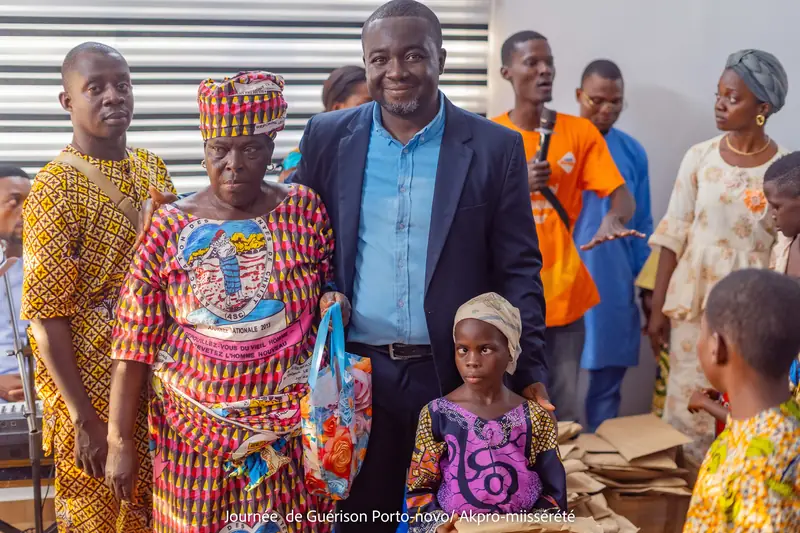 Une grand-mère et une fillette repartent avec leur kit, aux côtés du serviteur de Dieu
