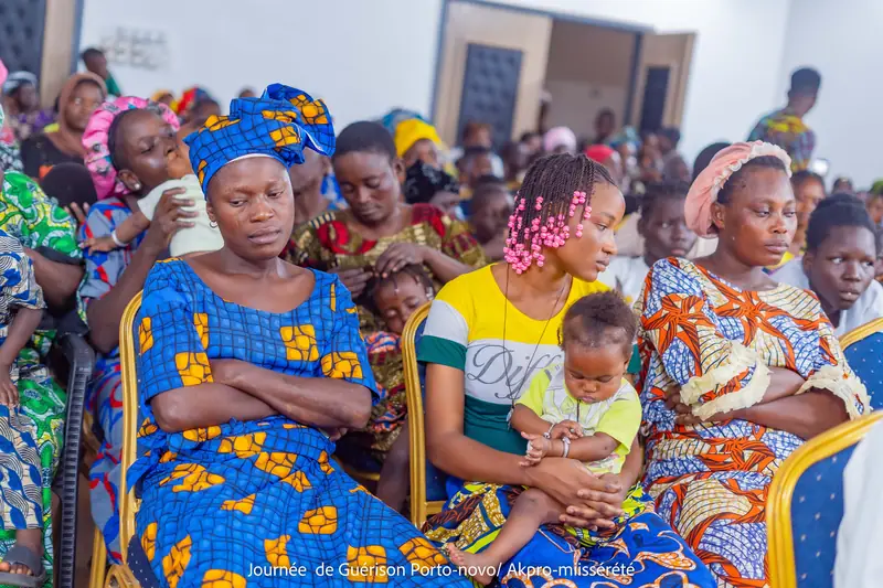 Salle de conférence comble : mères, enfants et familles assis serrés